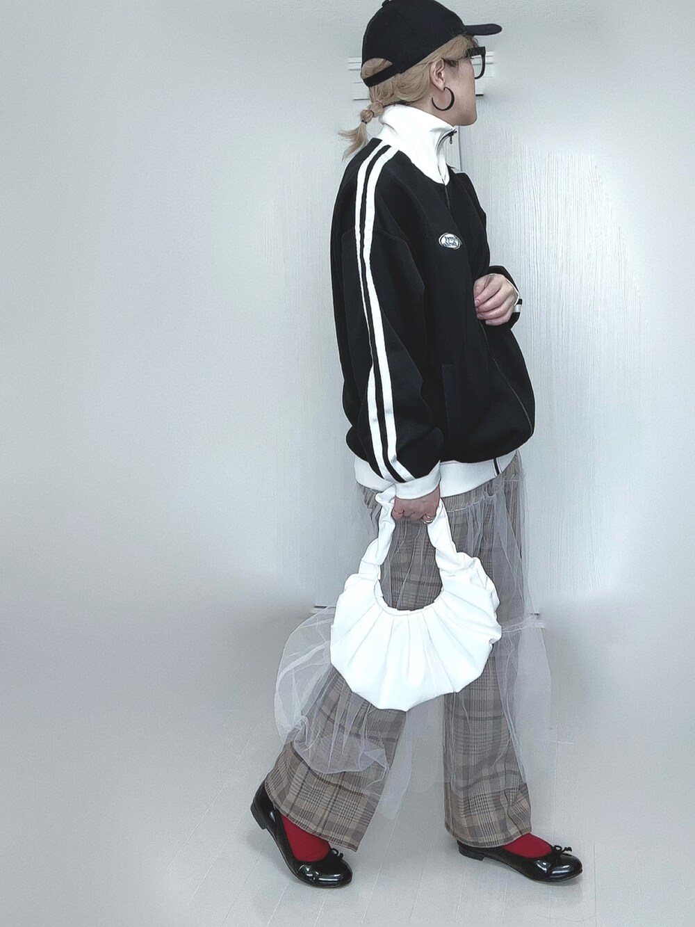 ブラック系のブルゾン、ホワイト系のスカート、ベージュ系のその他パンツを着用したレディースの春コーディネートの5枚目の写真