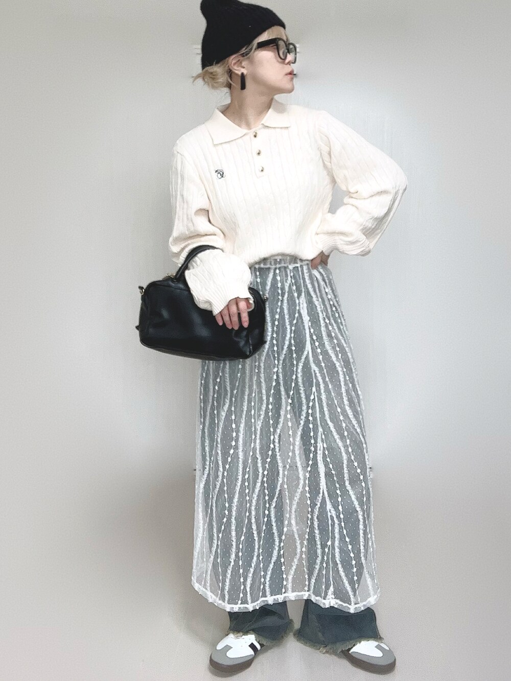 ホワイト系のニット/セーター、ブルー系のデニムパンツ、ホワイト系のスカートを着用したレディースの冬コーディネートの5枚目の写真