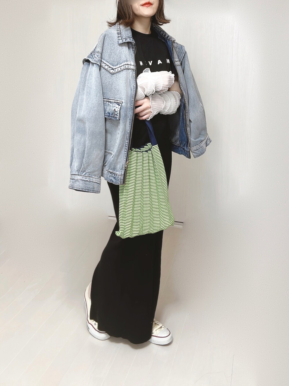 ブルー系のブルゾン、ブラック系のTシャツ/カットソー、グリーン系のトートバッグを着用したレディースの春コーディネートの5枚目の写真