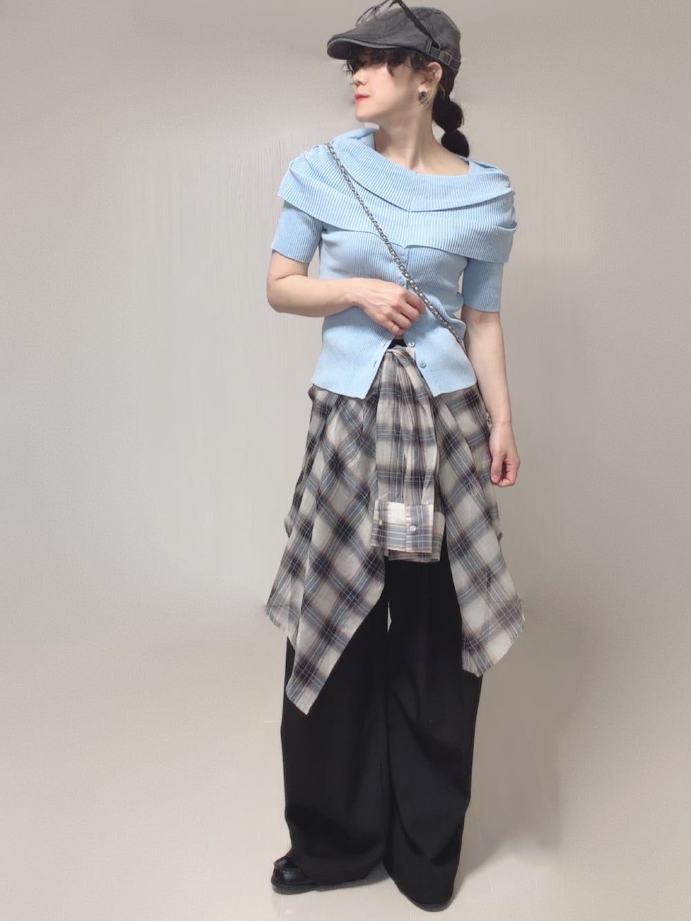 ブルー系のニット/セーター、ホワイト系のシャツ/ブラウス、ブラック系のスラックスを着用したレディースの春コーディネートの5枚目の写真