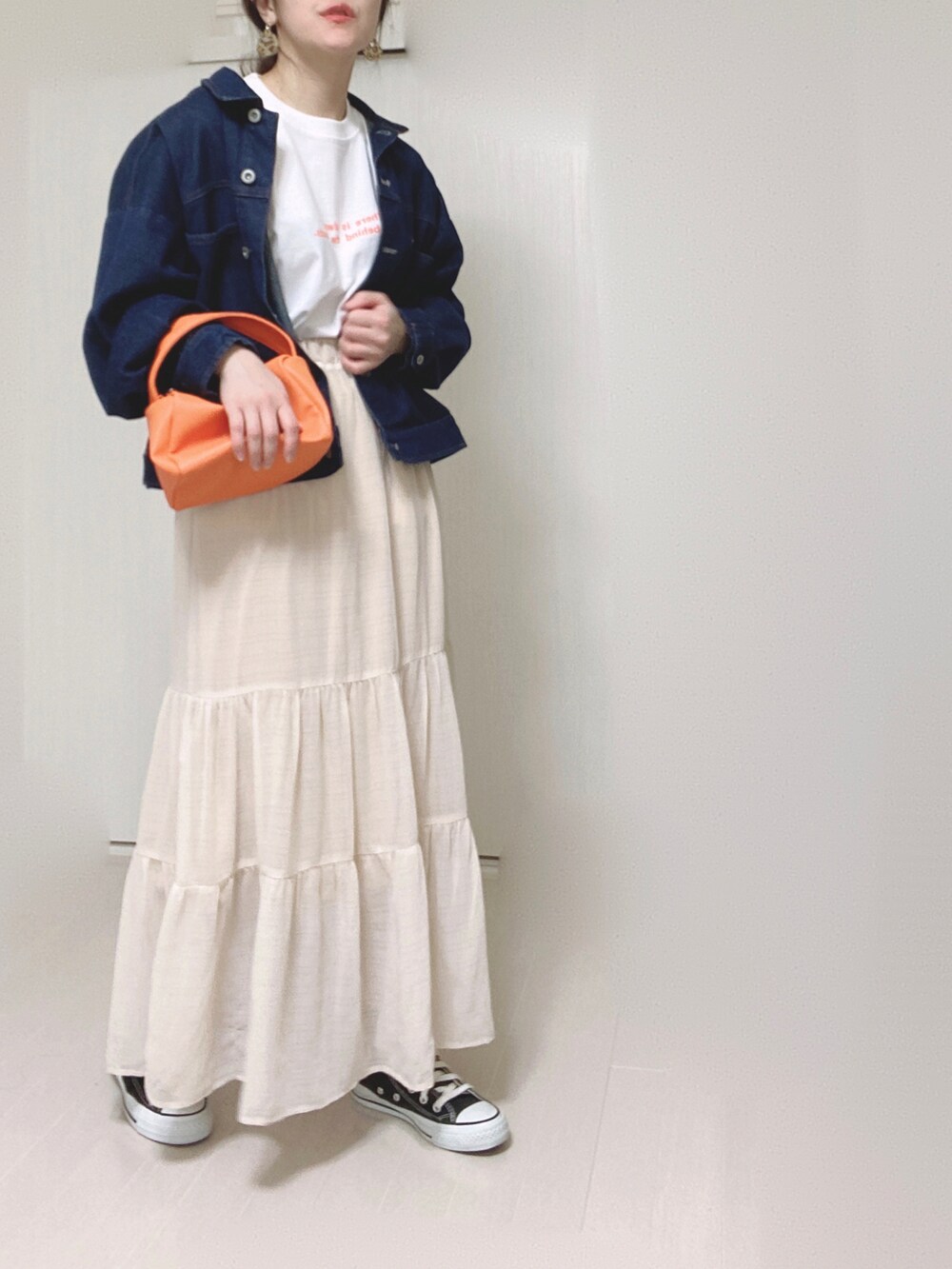 オレンジ系のTシャツ/カットソー、ブルー系のデニムジャケット、オレンジ系のショルダーバッグを着用したレディースの春コーディネートの3枚目の写真