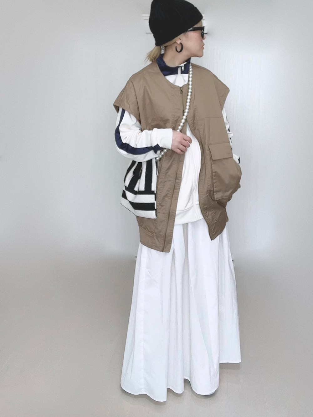 ベージュ系のジャケット/アウター、ベージュ系のジャージ、ホワイト系のショルダーバッグを着用したレディースの冬コーディネートの3枚目の写真