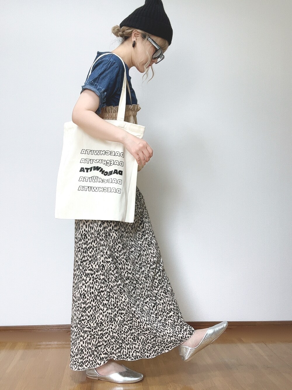 オレンジ系のキャミソール、ベージュ系のスカート、シルバー系のパンプスを着用したレディースの夏コーディネートの2枚目の写真