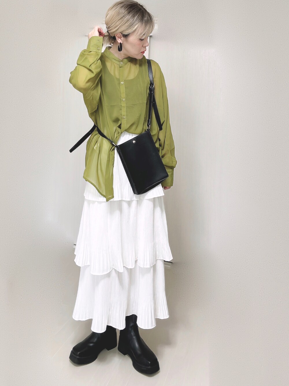 ホワイト系のスカート、グリーン系のシャツ/ブラウス、ブラック系のブーツを着用したレディースの秋コーディネートの2枚目の写真