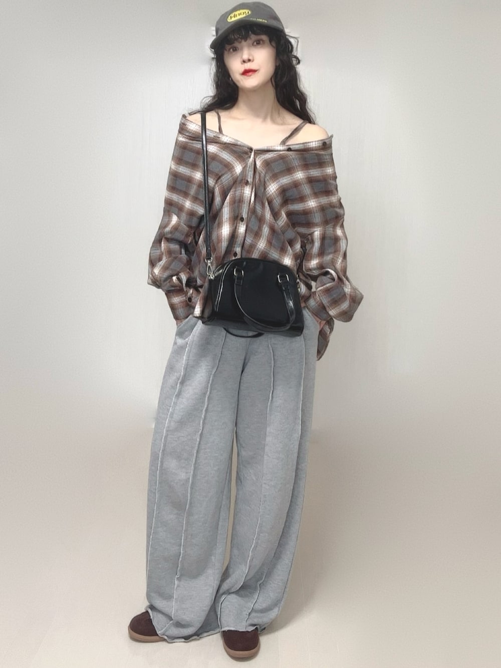 ブラウン系のシャツ/ブラウス、グレー系のスウェットパンツ、ブラック系のボストンバッグを着用したレディースの春コーディネートの2枚目の写真