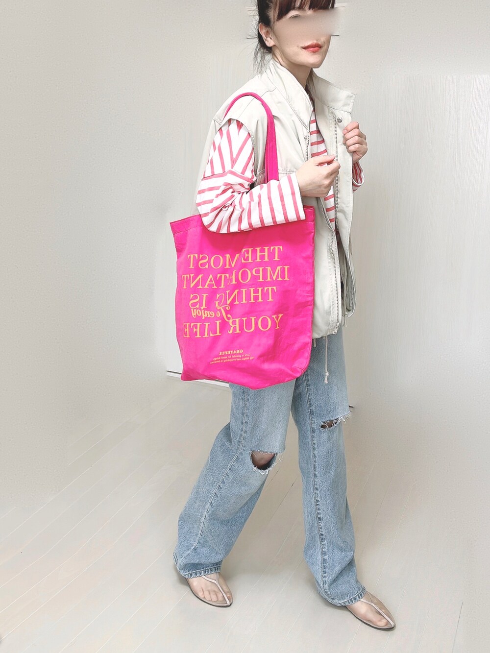 ブルー系のデニムパンツ、ホワイト系のベスト、ピンク系のTシャツ/カットソーを着用したレディースの春コーディネートの2枚目の写真