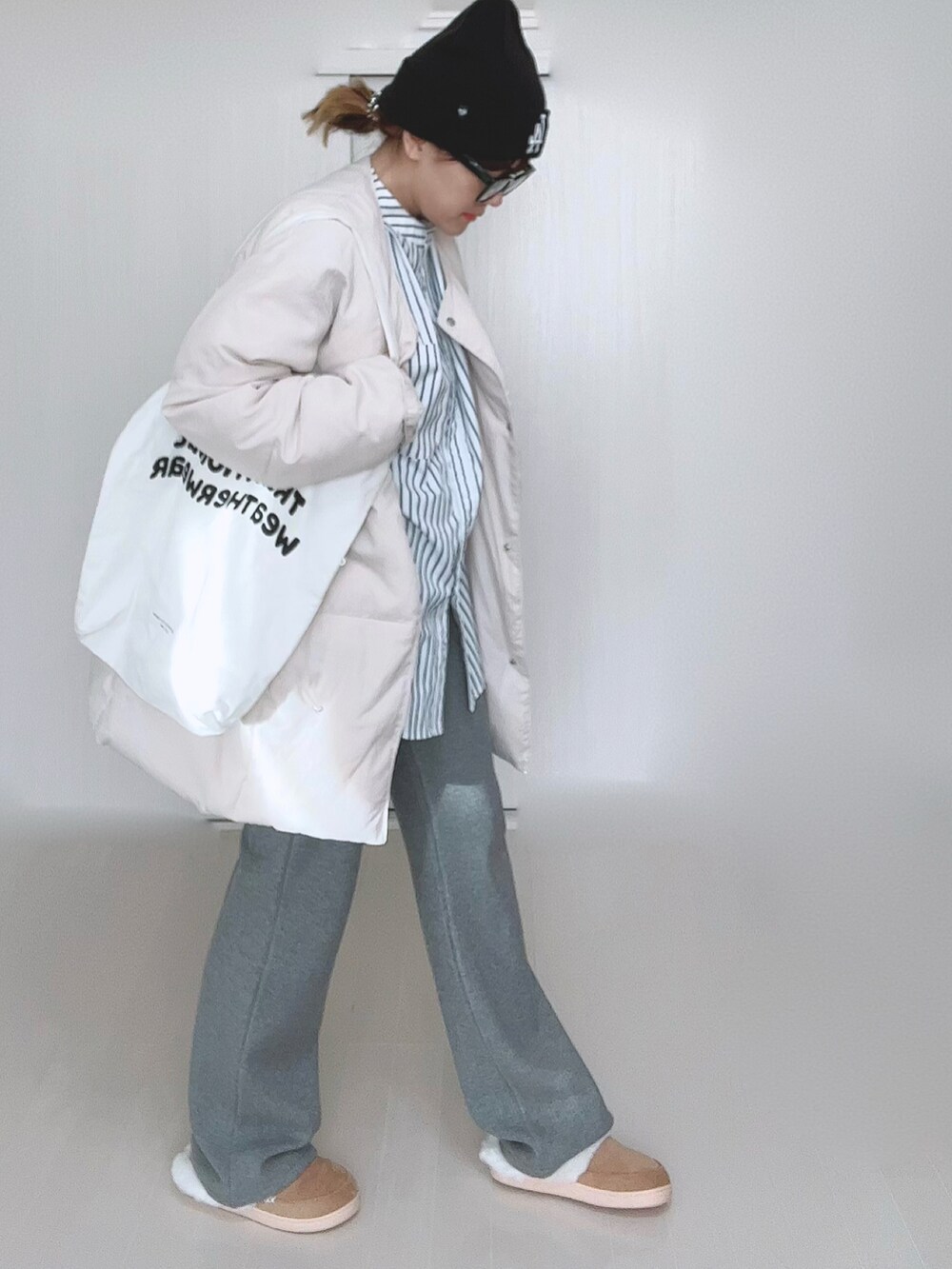 ホワイト系のダウンジャケット/コート、ホワイト系のシャツ/ブラウス、ホワイト系のトートバッグを着用したレディースの冬コーディネートの5枚目の写真