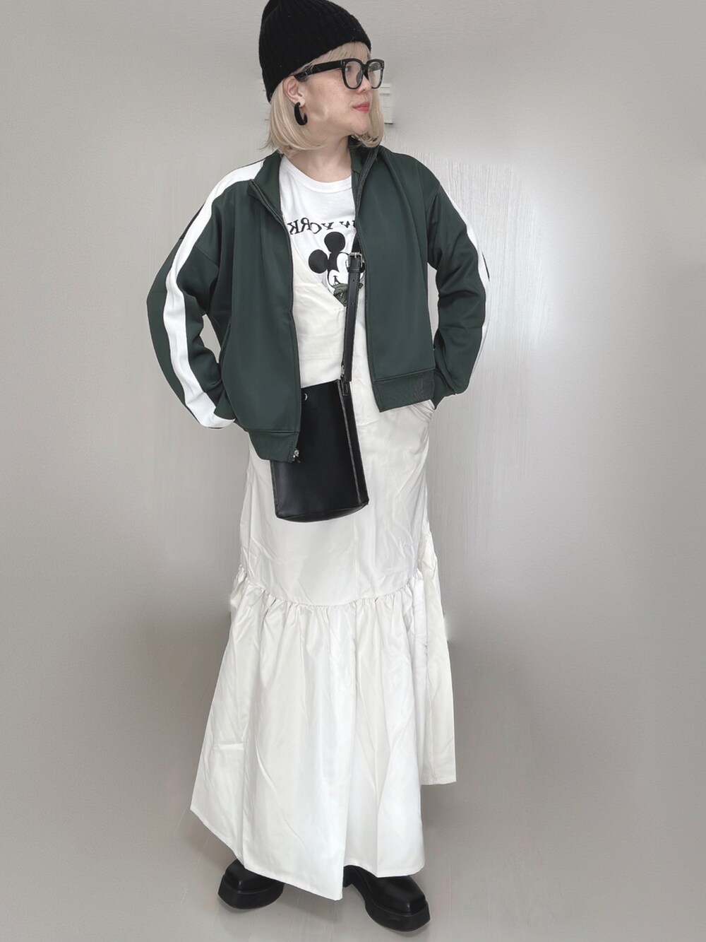 ホワイト系のジャンパースカート、グリーン系のその他アウター、ホワイト系のTシャツ/カットソーを着用したレディースの秋コーディネートの3枚目の写真