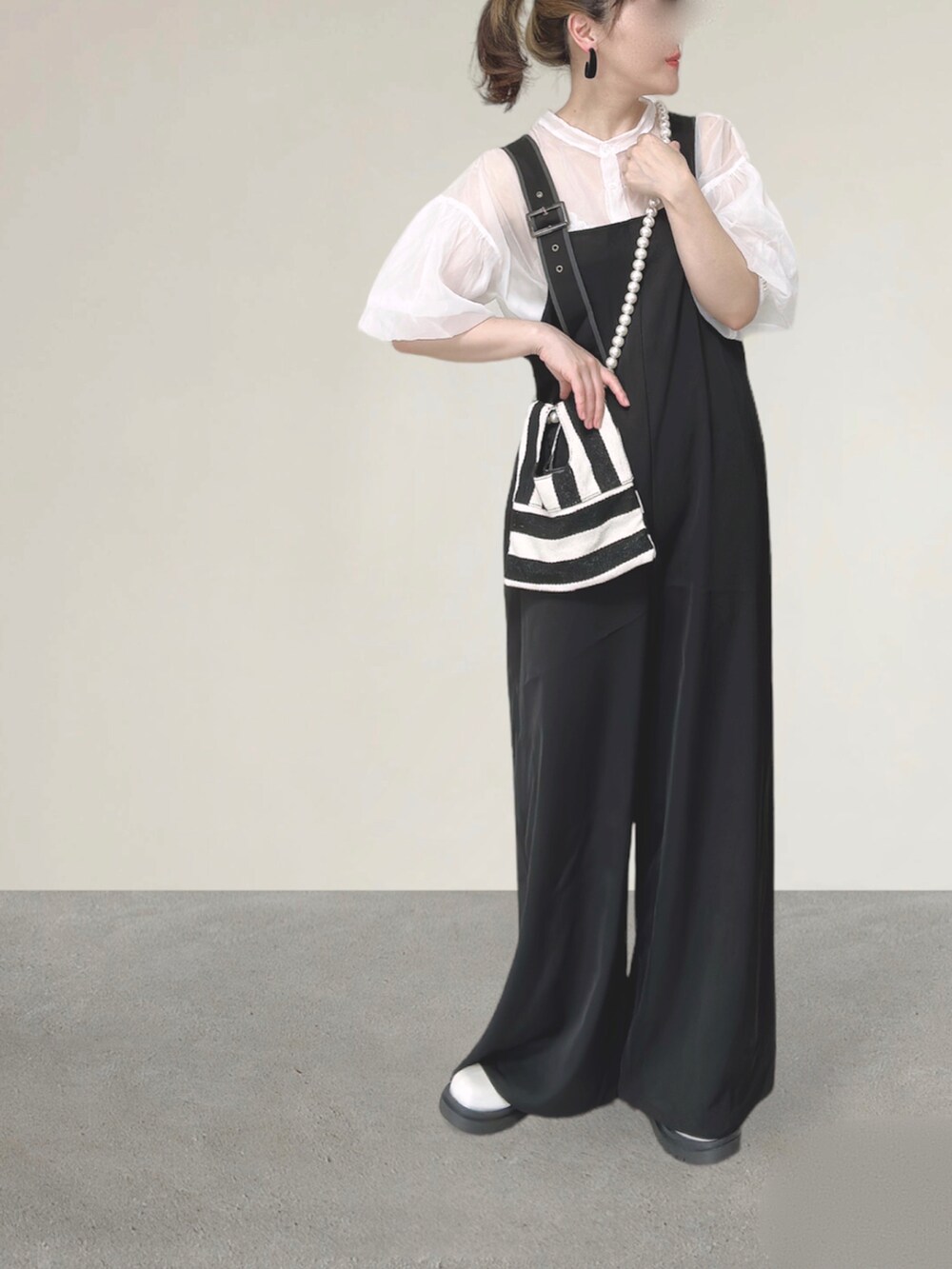 ブラック系のサロペット/オーバーオール、ホワイト系のシャツ/ブラウス、ホワイト系のショルダーバッグを着用したレディースの秋コーディネートの2枚目の写真