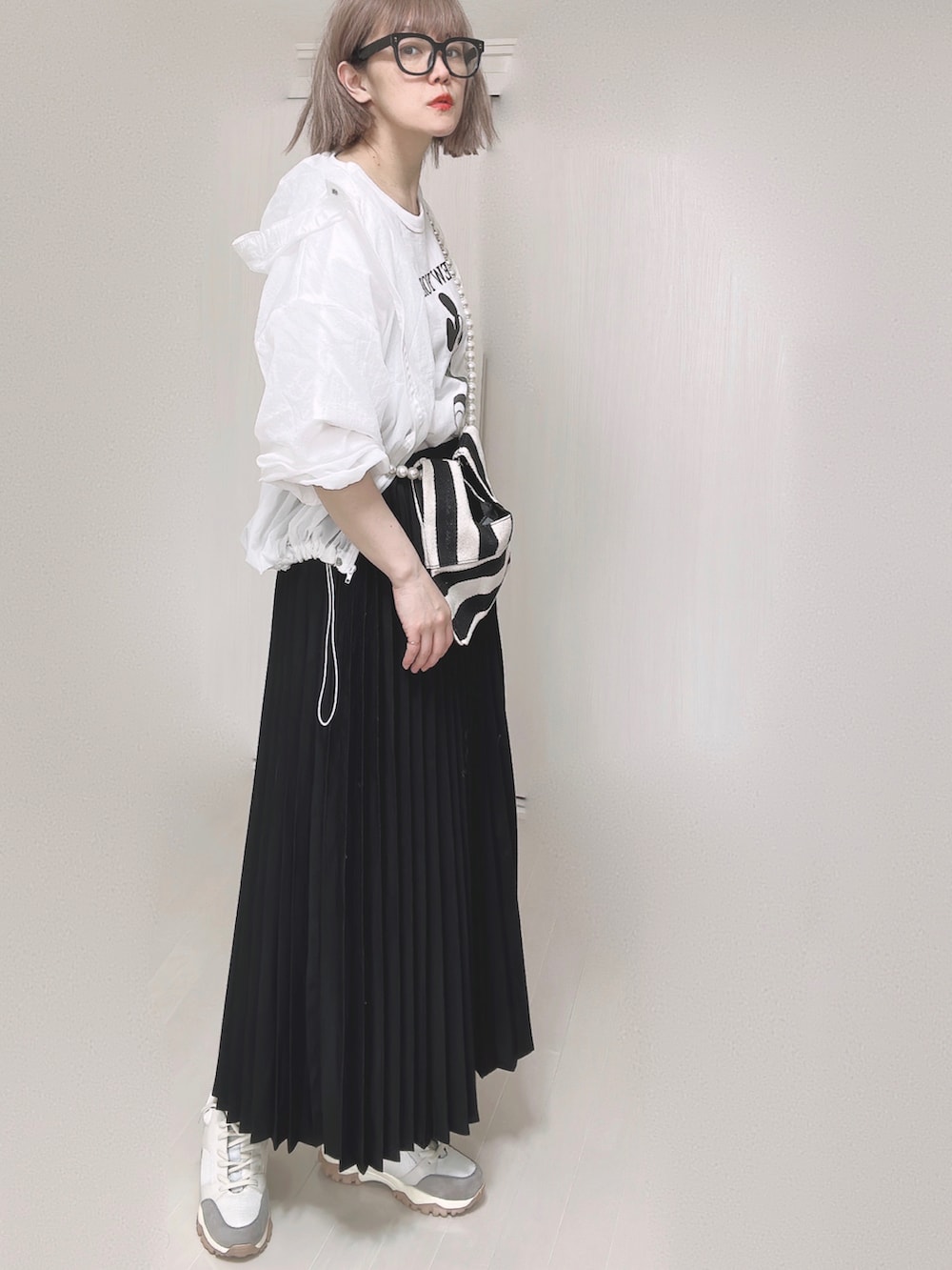 ホワイト系のTシャツ/カットソー、ホワイト系のショルダーバッグ、ブラック系のスカートを着用したレディースの春コーディネートの2枚目の写真