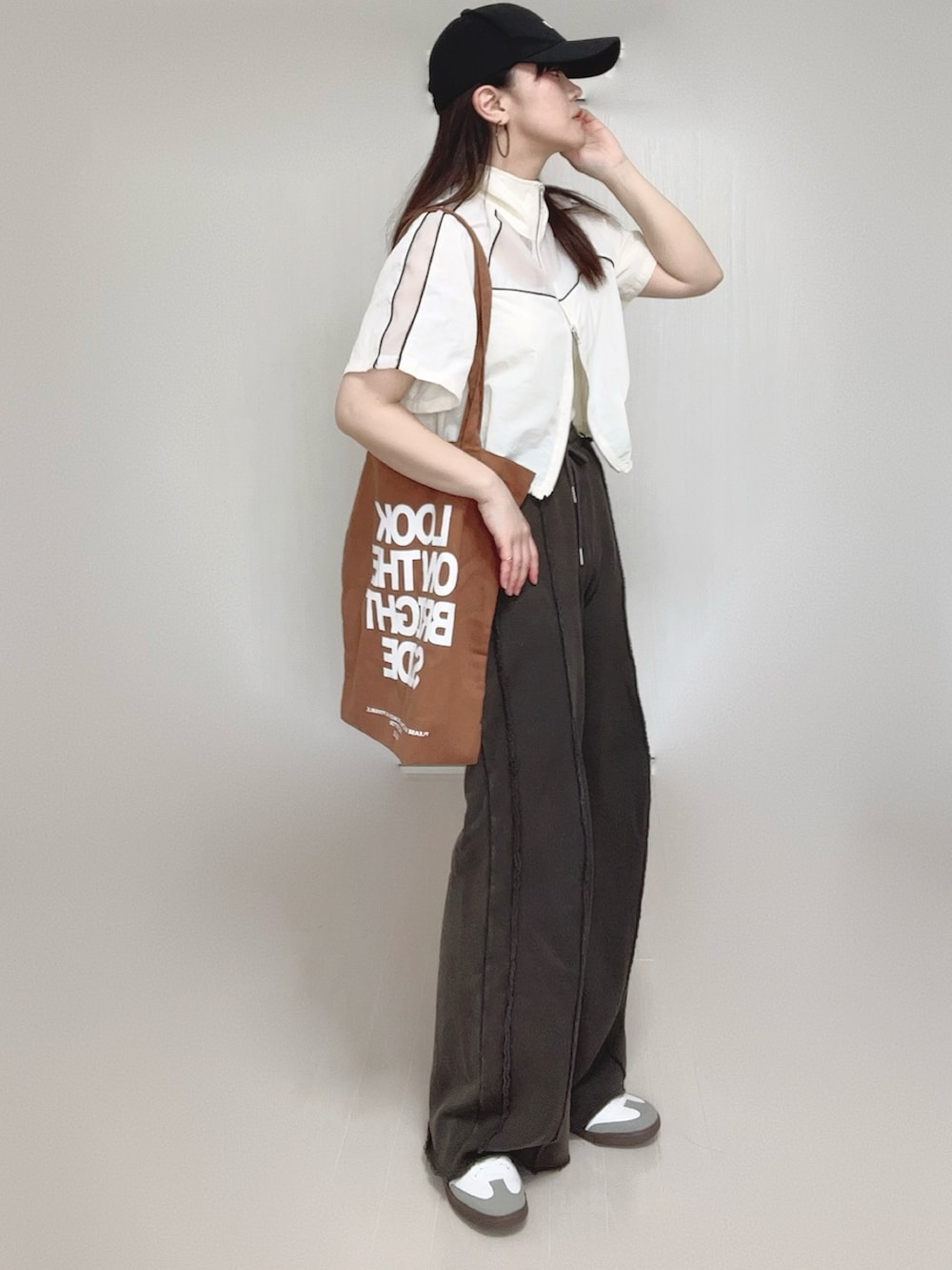 ブラック系のスウェットパンツ、ホワイト系のキャミソール、ホワイト系のブルゾンを着用したレディースの春コーディネートの3枚目の写真