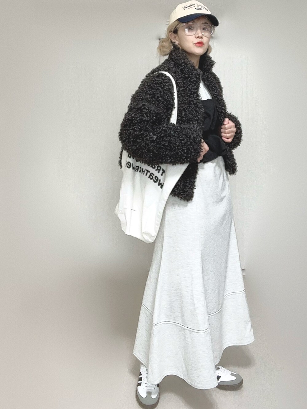 グレー系のブルゾン、グレー系のワンピース、ホワイト系のトートバッグを着用したレディースの秋コーディネートの5枚目の写真