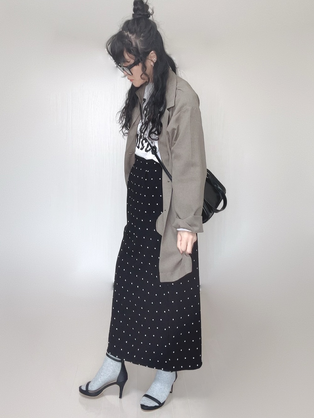 ベージュ系のテーラードジャケット、ブラック系のボストンバッグ、ブラック系のサンダルを着用したレディースの春コーディネートの5枚目の写真