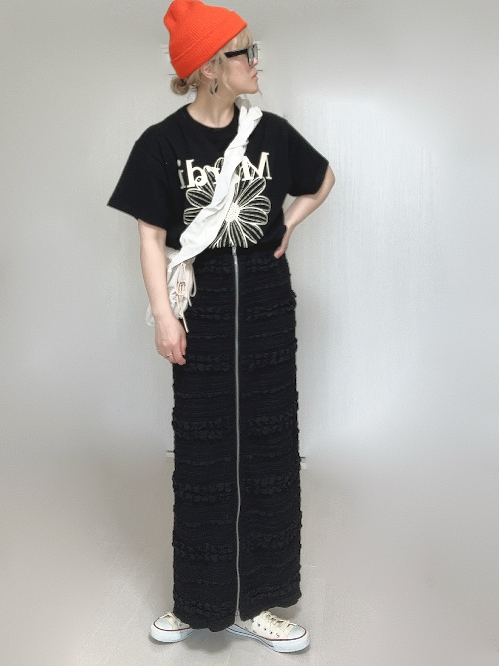 ブラック系のスカート、ホワイト系のショルダーバッグ、ブラック系のTシャツ/カットソーを着用したレディースの夏コーディネートの2枚目の写真