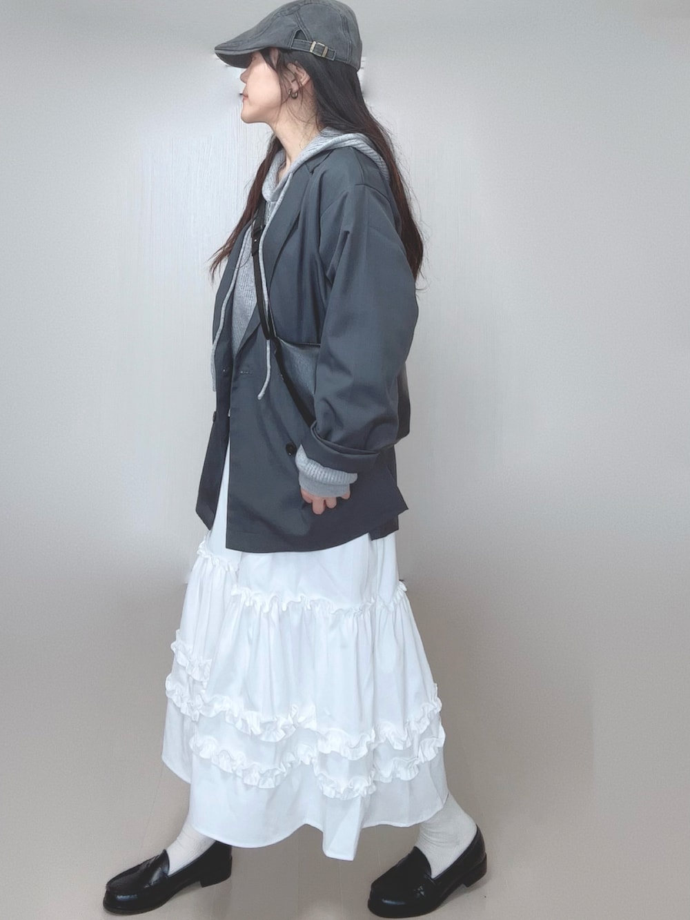 グレー系のパーカー、グレー系のテーラードジャケット、ホワイト系のスカートを着用したレディースの春コーディネートの5枚目の写真