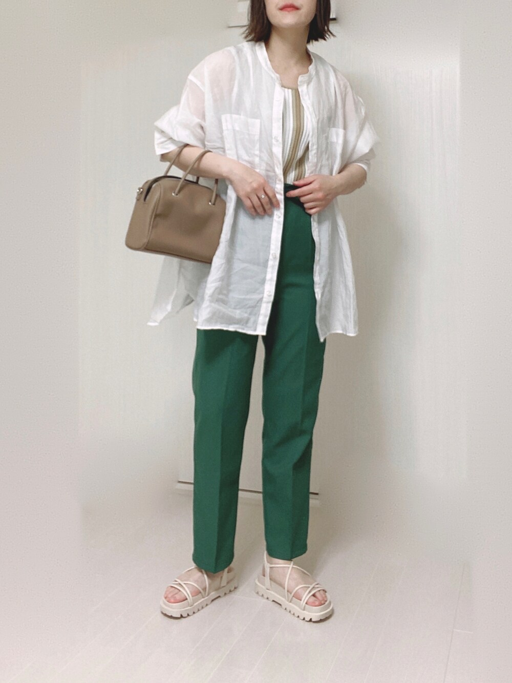 ホワイト系のサンダル、ホワイト系のシャツ/ブラウス、ベージュ系のタンクトップを着用したレディースの春コーディネートの3枚目の写真
