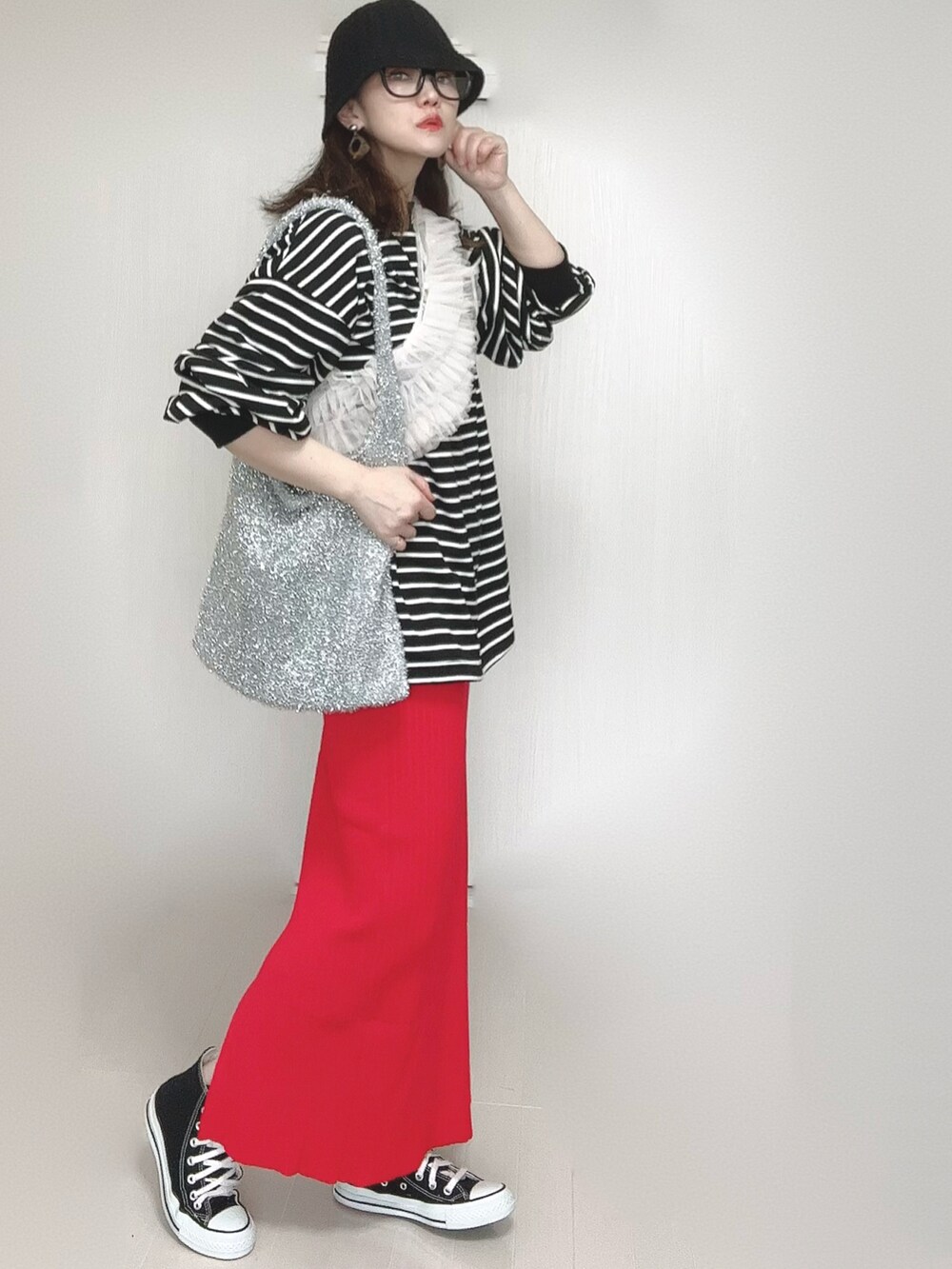 レッド系のスカート、ブラック系のTシャツ/カットソー、ブラック系のスニーカーを着用したレディースの春コーディネートの3枚目の写真