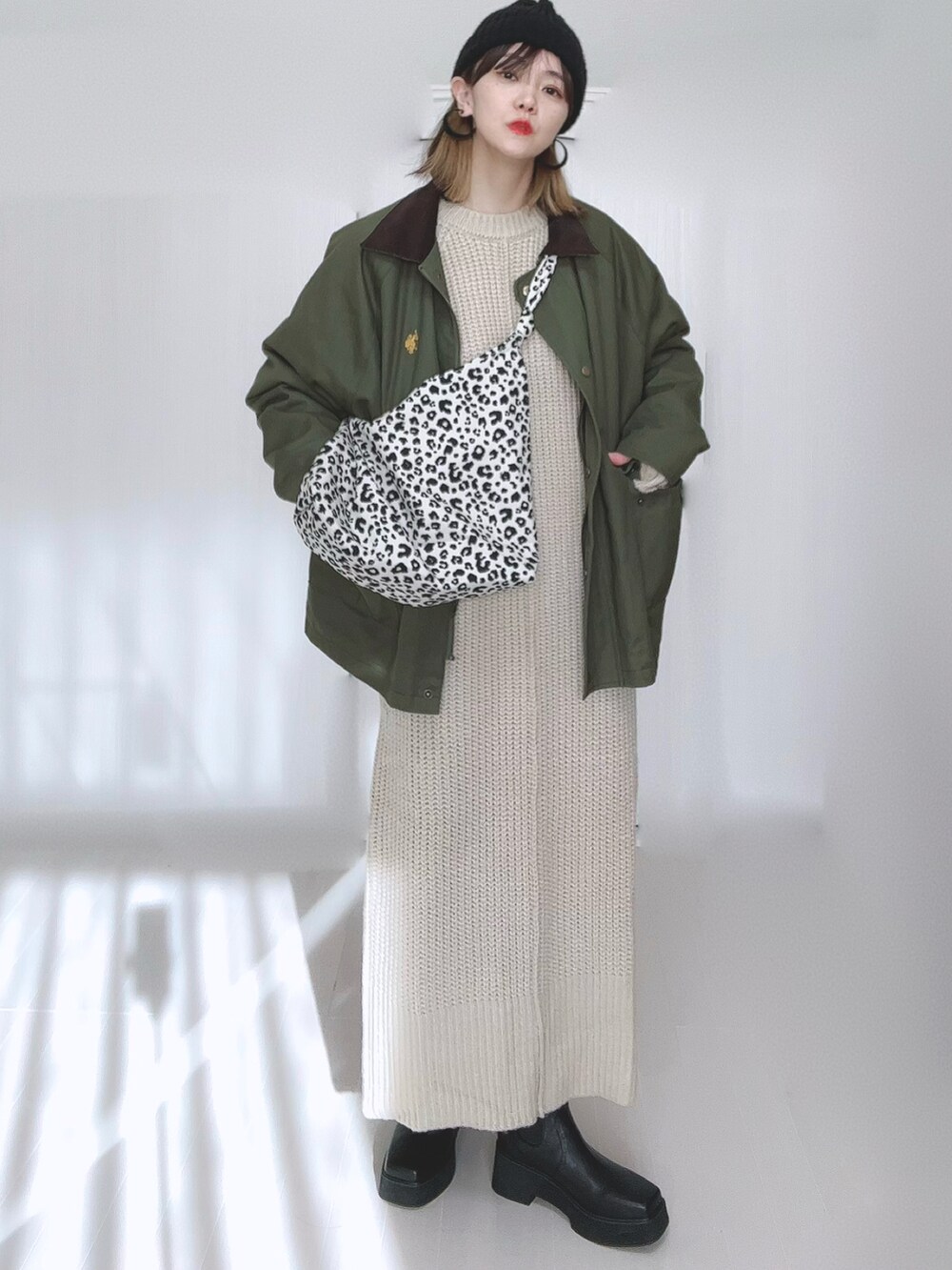 グリーン系のカバーオール、ホワイト系のトートバッグ、ホワイト系のワンピースを着用したレディースの冬コーディネートの2枚目の写真