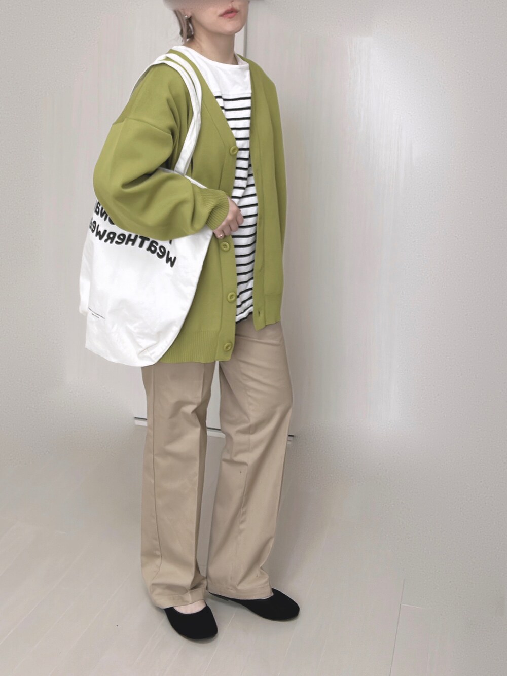 ベージュ系のチノパンツ、グリーン系のカーディガン/ボレロ、ブラック系のTシャツ/カットソーを着用したレディースの冬コーディネートの5枚目の写真