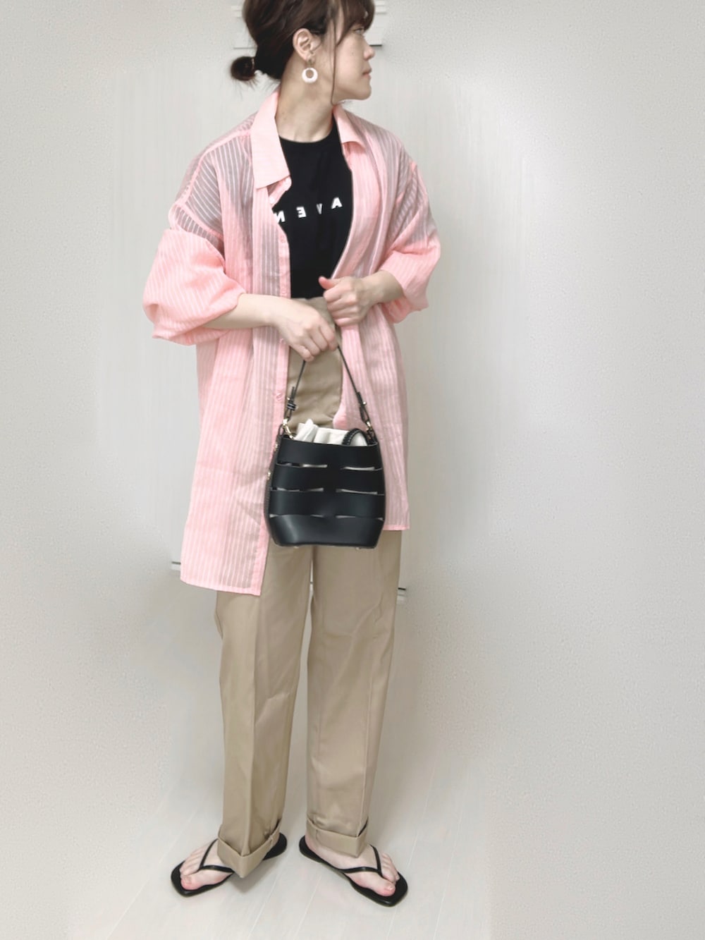 ブラック系のTシャツ/カットソー、ピンク系のシャツ/ブラウス、ベージュ系のチノパンツを着用したレディースの春コーディネートの5枚目の写真