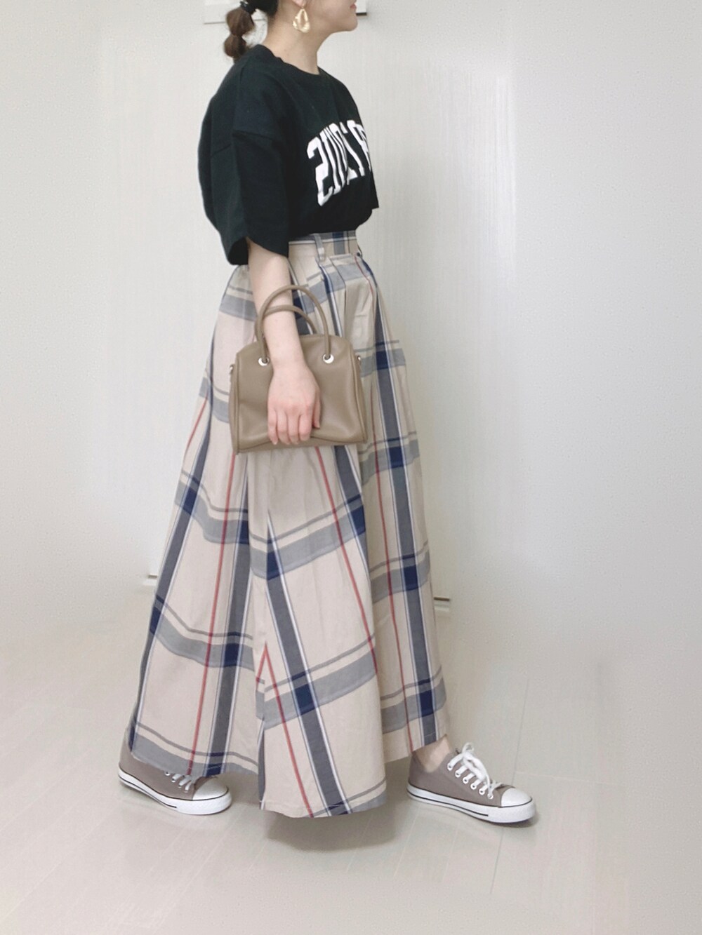 ブラック系のTシャツ/カットソーを着用したレディースの春コーディネートの2枚目の写真