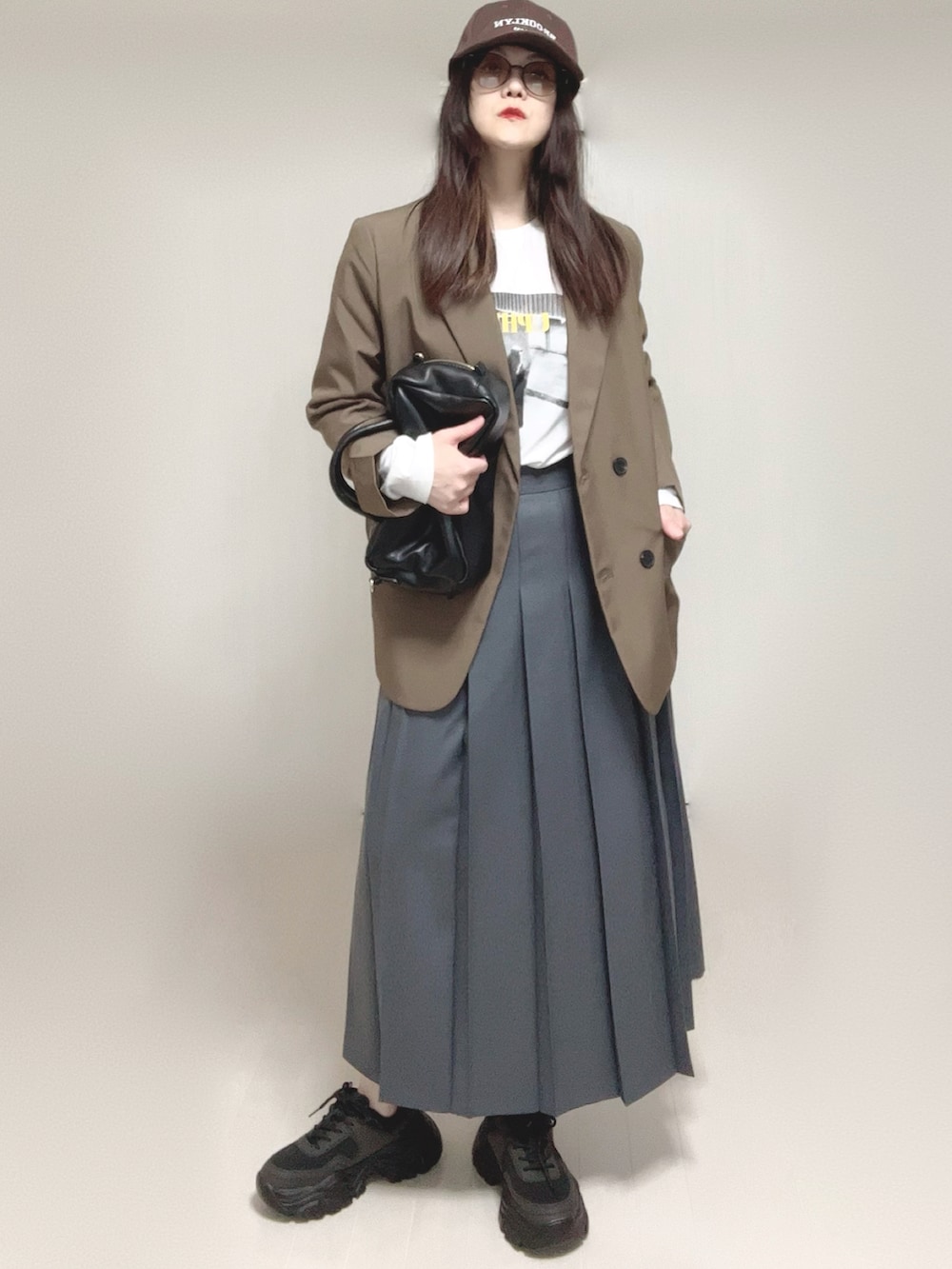 ブラウン系のテーラードジャケット、ホワイト系のTシャツ/カットソー、ブラック系のボストンバッグを着用したレディースの春コーディネートの4枚目の写真