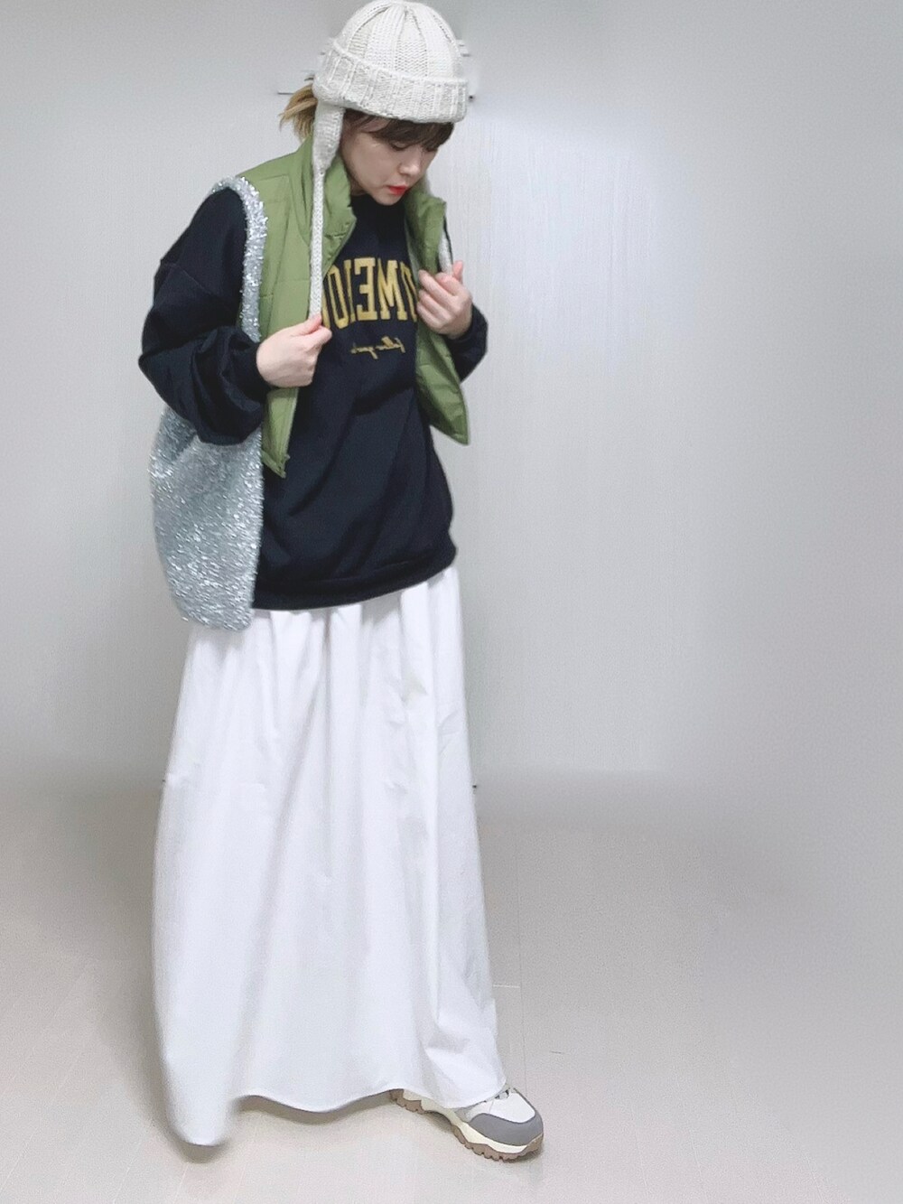 ホワイト系のスカート、ベージュ系のスニーカー、ベージュ系のニットキャップ/ビーニーを着用したレディースの冬コーディネートの2枚目の写真