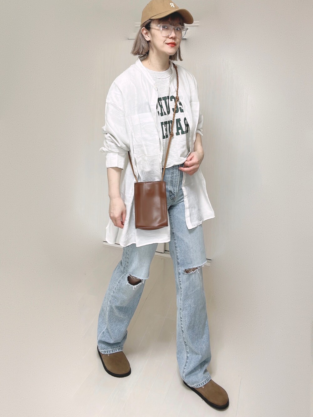 ブルー系のデニムパンツ、ホワイト系のシャツ/ブラウス、ブラウン系のショルダーバッグを着用したレディースの春コーディネートの5枚目の写真