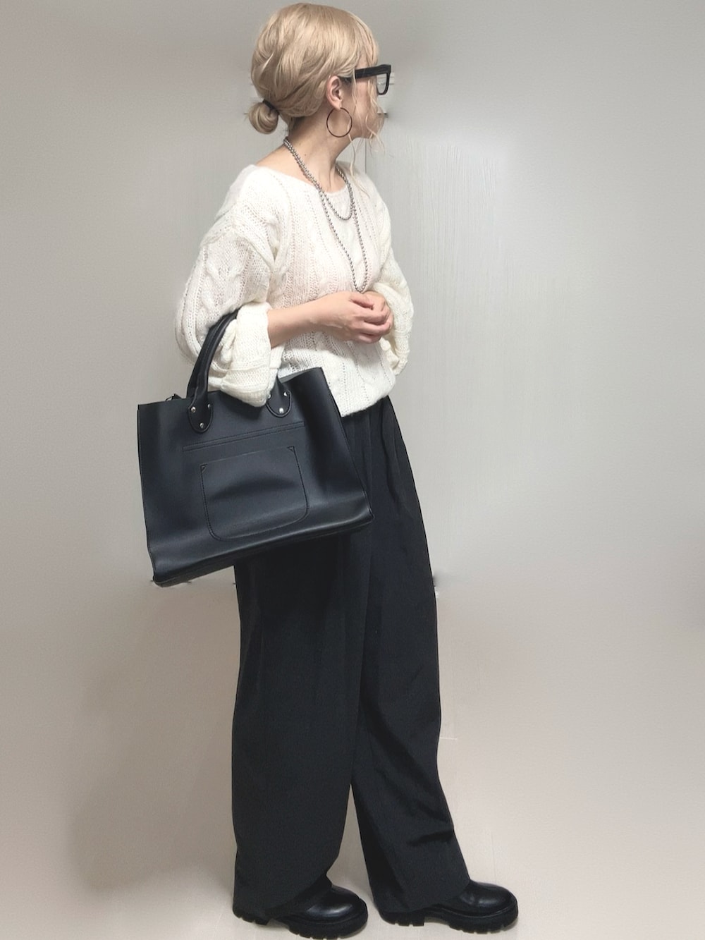 ホワイト系のニット/セーター、ブラック系のブーツ、ブラック系のトートバッグを着用したレディースの夏コーディネートの3枚目の写真