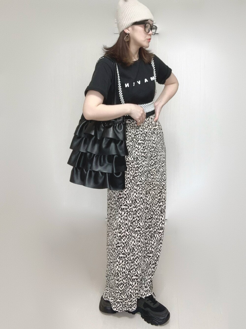 ベージュ系のスカート、ブラック系のTシャツ/カットソー、ブラック系のスニーカーを着用したレディースの春コーディネートの4枚目の写真