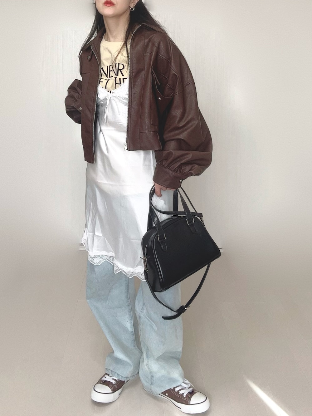 ベージュ系のTシャツ/カットソー、ブラウン系のブルゾン、ホワイト系のワンピースを着用したレディースの冬コーディネートの3枚目の写真