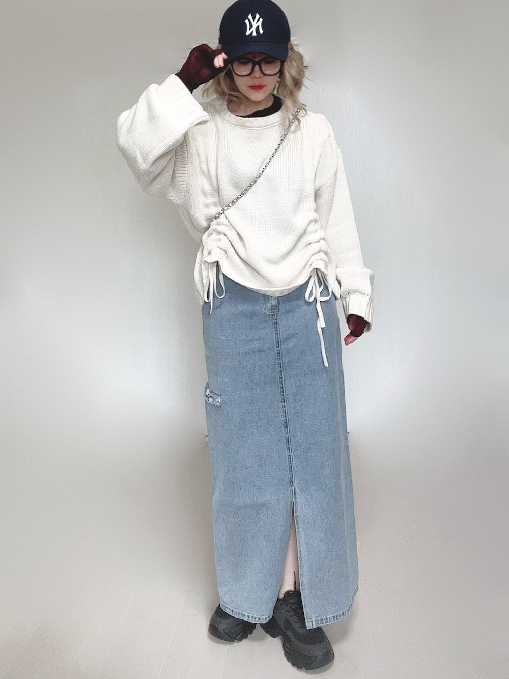 ホワイト系のニット/セーター、ブラウン系のTシャツ/カットソー、シルバー系のショルダーバッグを着用したレディースの冬コーディネートの4枚目の写真