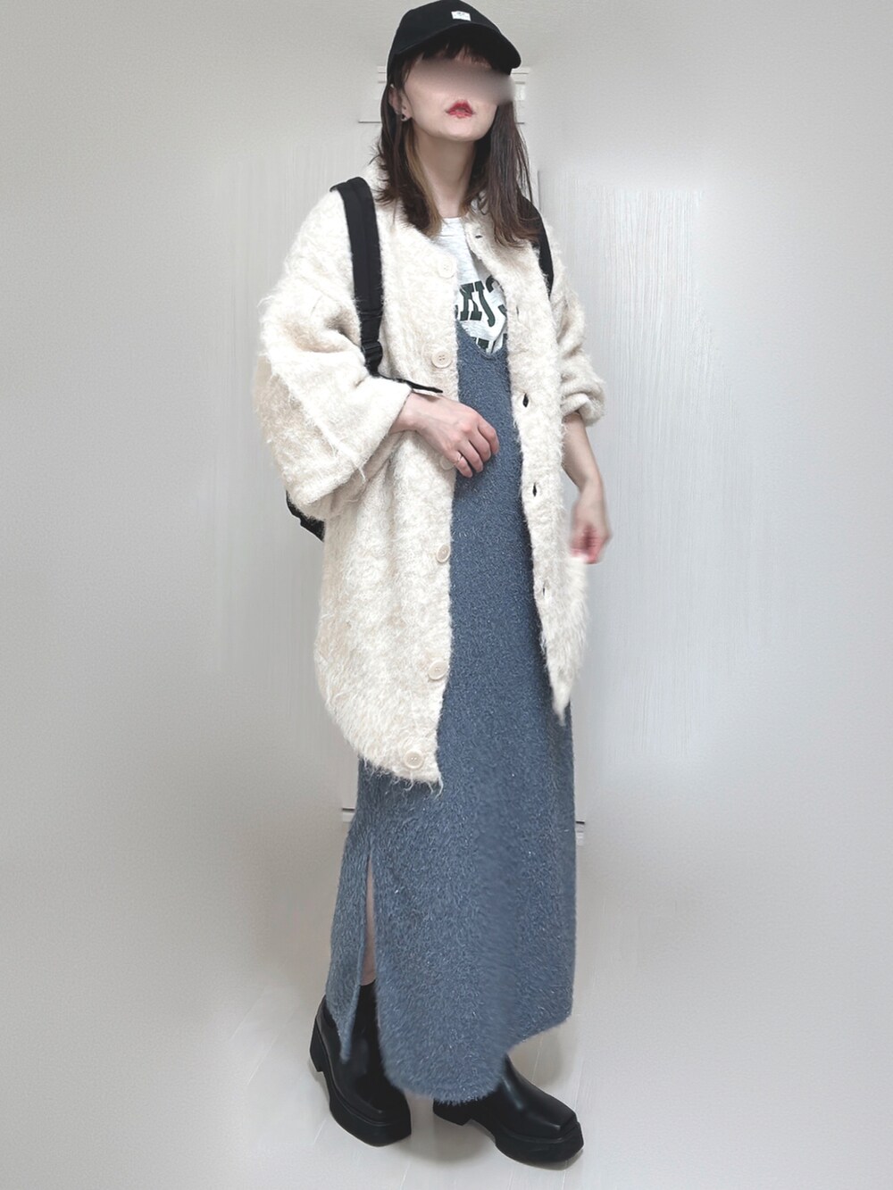 ベージュ系のカーディガン/ボレロ、ブラック系のブーツ、ブラック系のバックパック/リュックを着用したレディースの秋コーディネートの5枚目の写真