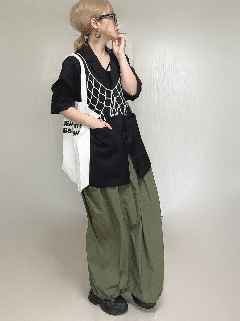 ブラック系のテーラードジャケット、ブラック系のキャミソール、ホワイト系のベストを着用したレディースの夏コーディネートの5枚目の写真