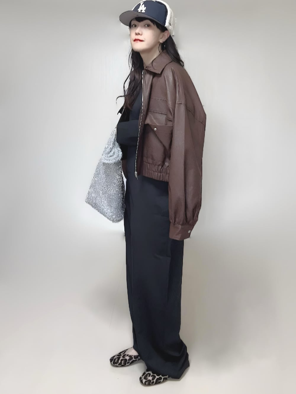 ブラック系のカーディガン/ボレロ、ブラウン系のブルゾン、ブラック系のつなぎ/オールインワンを着用したレディースの冬コーディネートの3枚目の写真