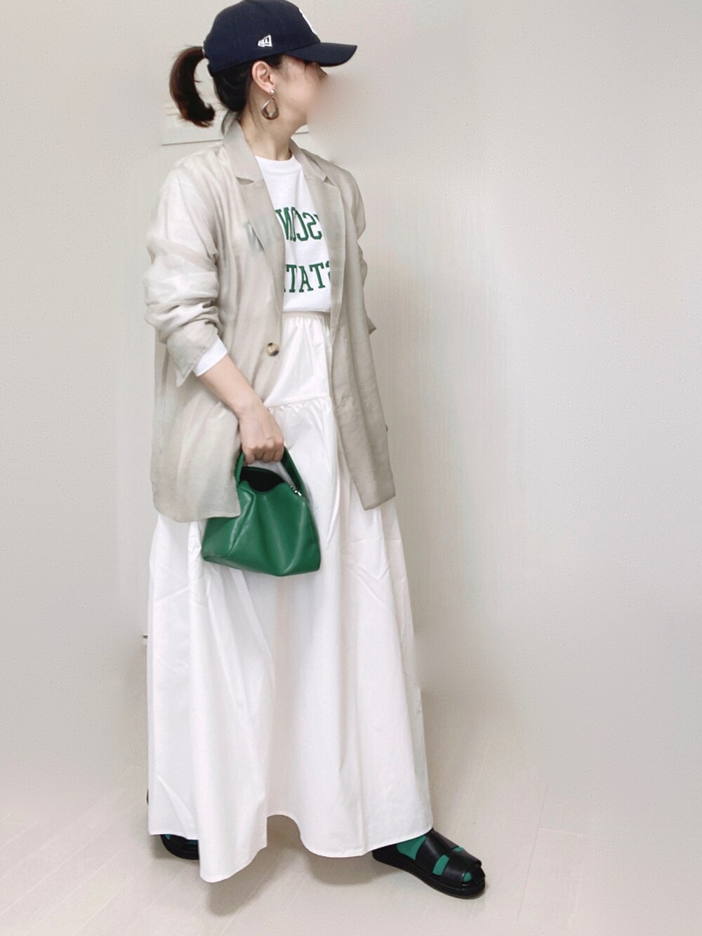 グレー系のテーラードジャケット、ホワイト系のTシャツ/カットソー、ホワイト系のスカートを着用したレディースの夏コーディネートの2枚目の写真
