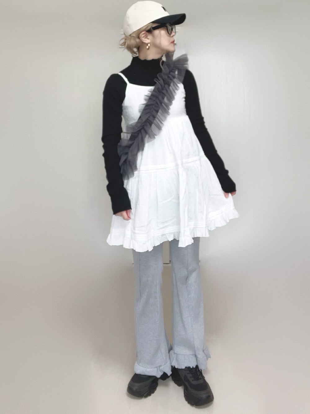 ホワイト系のワンピース、ブラック系のTシャツ/カットソー、グレー系のショルダーバッグを着用したレディースの春コーディネートの2枚目の写真