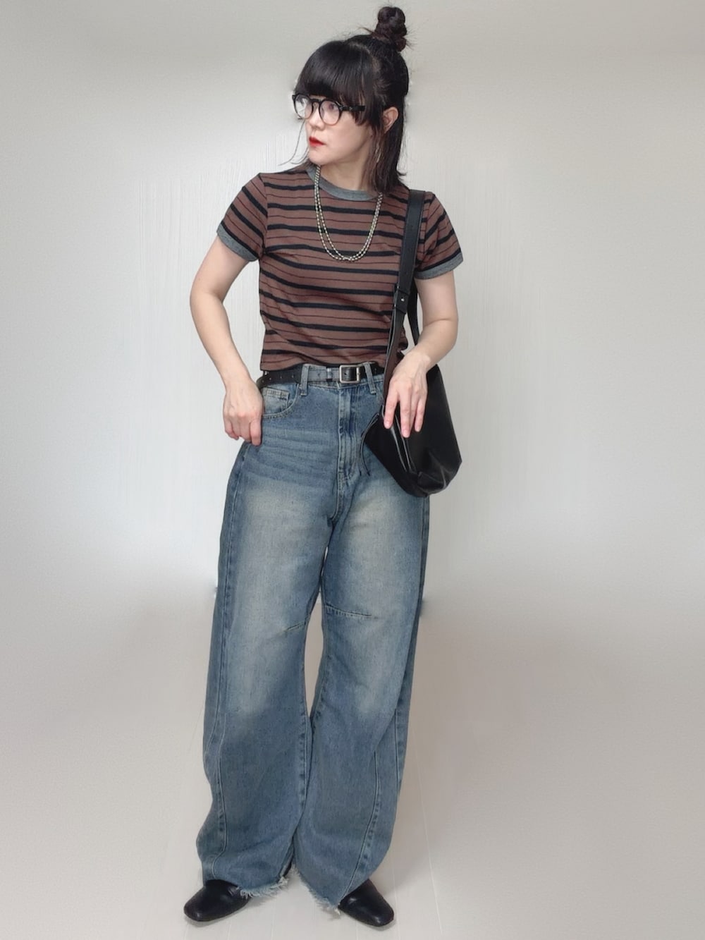 ブルー系のデニムパンツ、ブラウン系のTシャツ/カットソー、ブラック系のスリッポンを着用したレディースの秋コーディネートの2枚目の写真