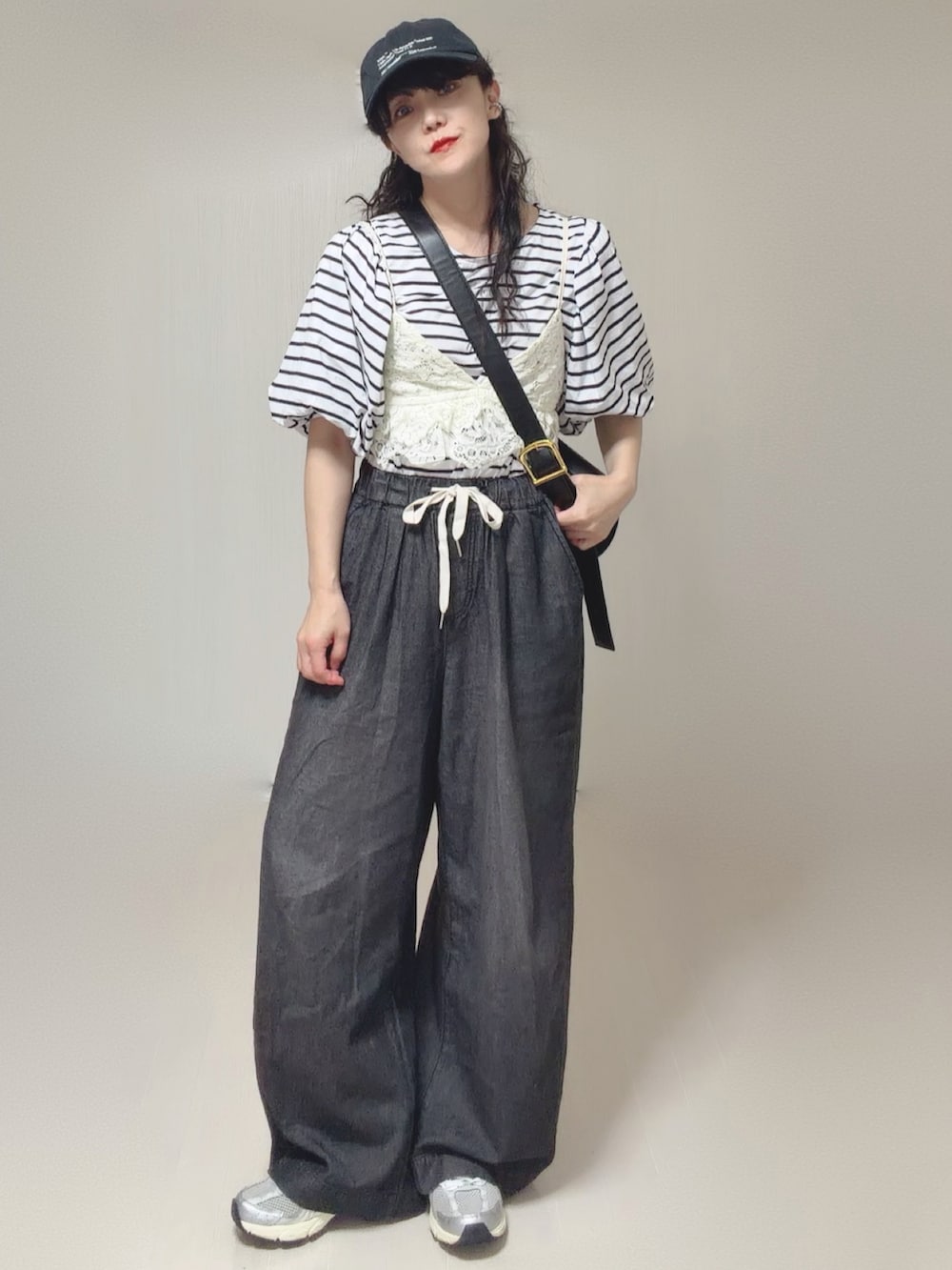 ホワイト系のキャミソール、ブラック系のTシャツ/カットソー、ブラック系のデニムパンツを着用したレディースの夏コーディネートの2枚目の写真
