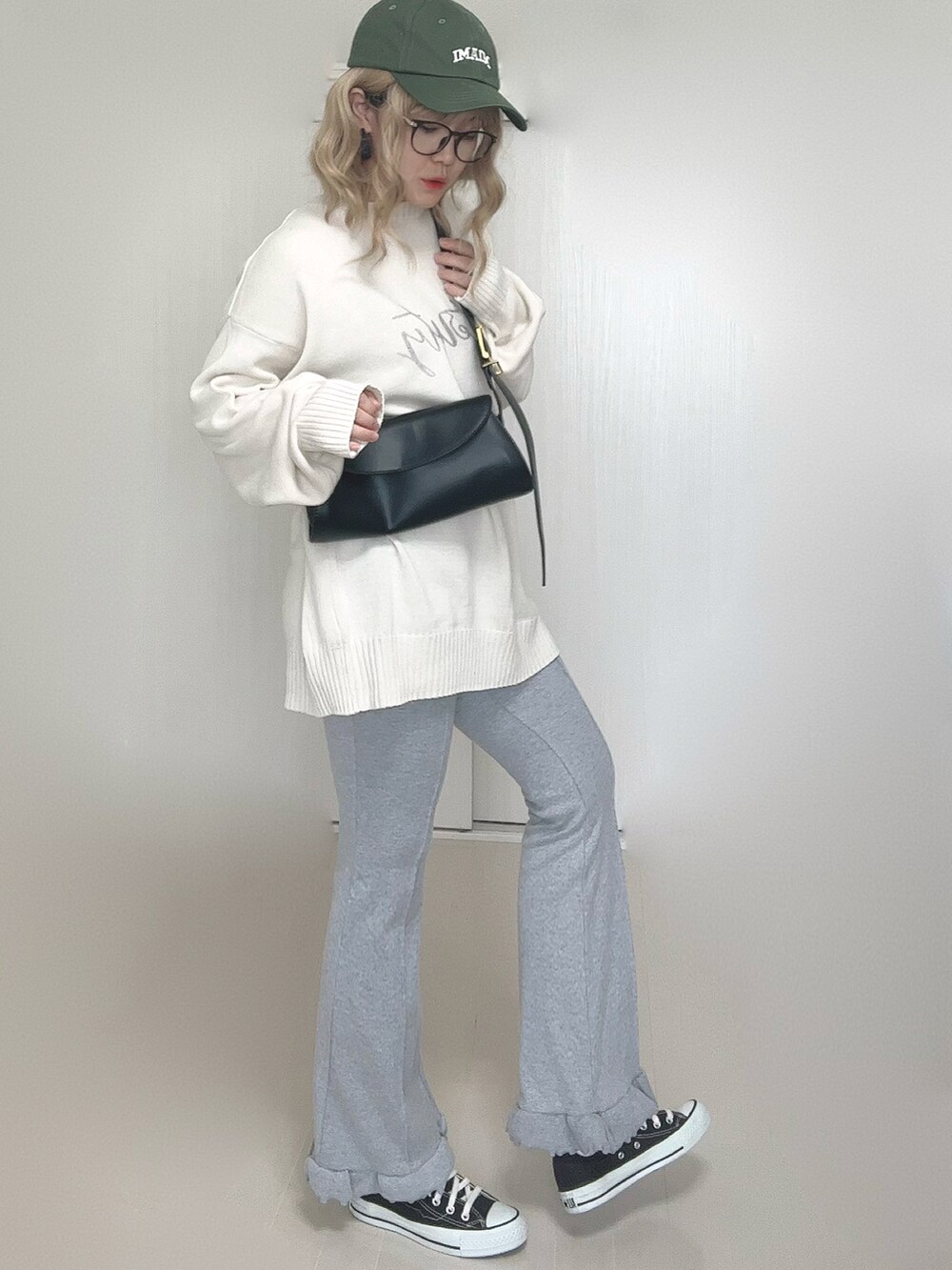 ホワイト系のニット/セーター、グレー系のその他パンツ、ブラック系のスニーカーを着用したレディースの秋コーディネートの5枚目の写真