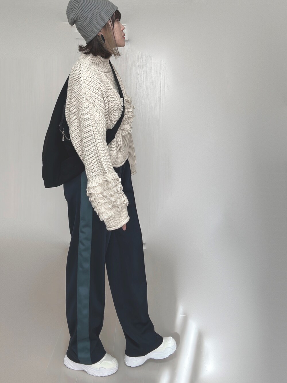 ブルー系のその他パンツ、ホワイト系のニット/セーター、ホワイト系のスニーカーを着用したレディースの秋コーディネートの4枚目の写真