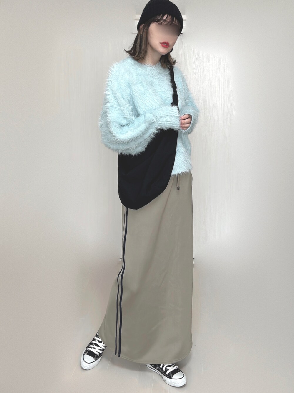 ブルー系のニット/セーター、ブルー系のスカート、ブラック系のスニーカーを着用したレディースの秋コーディネートの2枚目の写真