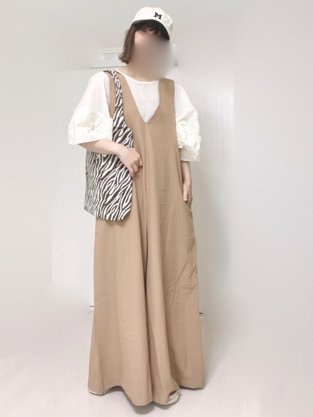 ベージュ系のサロペット/オーバーオール、ホワイト系のシャツ/ブラウス、ホワイト系のサンダルを着用したレディースの夏コーディネートの4枚目の写真