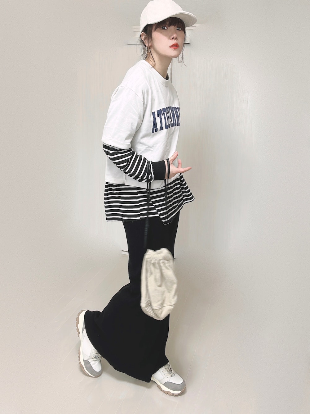 ホワイト系のTシャツ/カットソー、ベージュ系のハンドバッグ、ブラック系のスカートを着用したレディースの春コーディネートの4枚目の写真