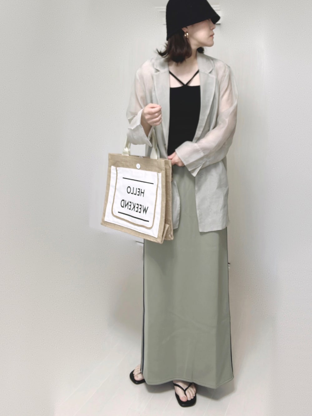 ブルー系のスカート、グレー系のテーラードジャケット、ブラック系のキャミソールを着用したレディースの夏コーディネートの2枚目の写真