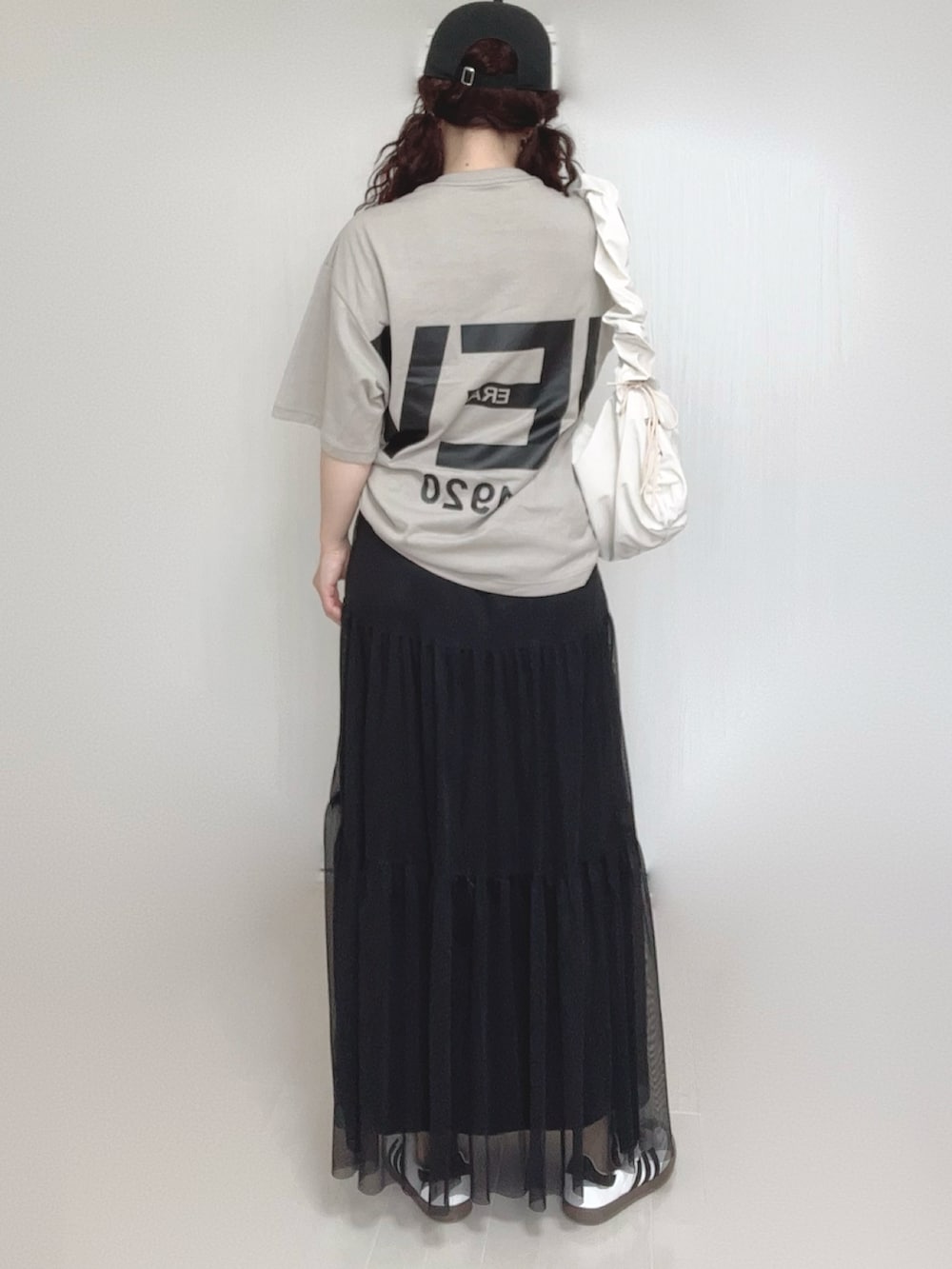 ベージュ系のTシャツ/カットソー、ホワイト系のショルダーバッグ、ブラック系のスカートを着用したレディースの夏コーディネートの4枚目の写真