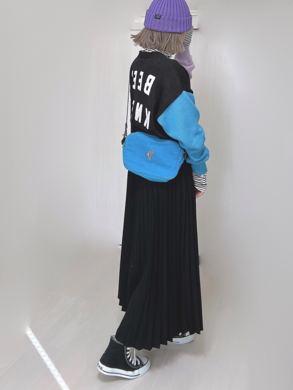 ブラック系のカーディガン/ボレロ、ブルー系のショルダーバッグ、ブラック系のスカートを着用したレディースの春コーディネートの3枚目の写真