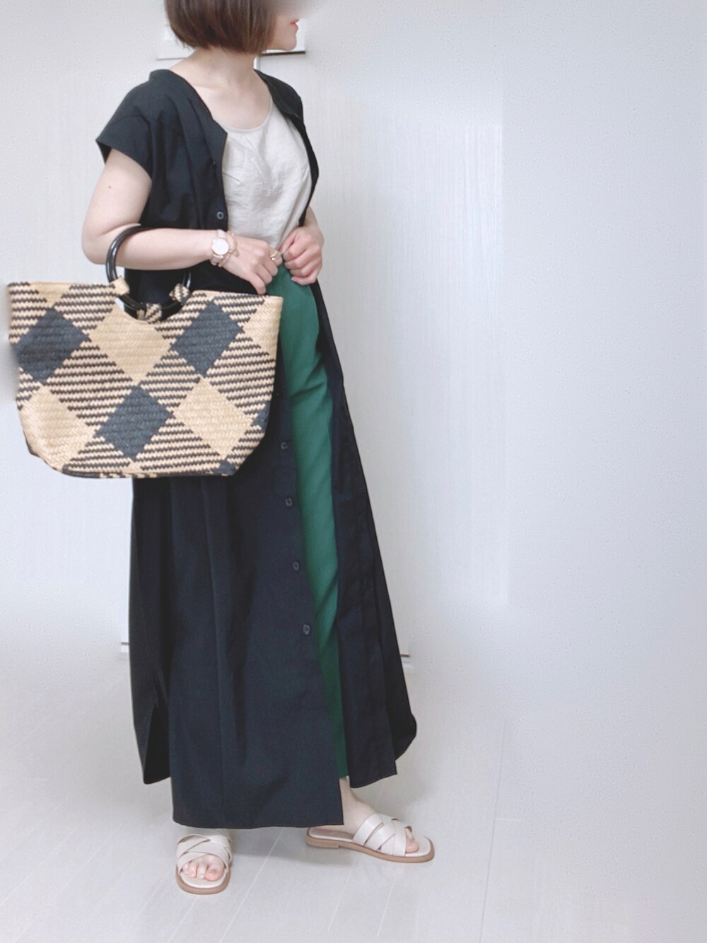 ブラック系のワンピース、ブラック系のトートバッグ、グリーン系のスラックスを着用したレディースの夏コーディネートの3枚目の写真