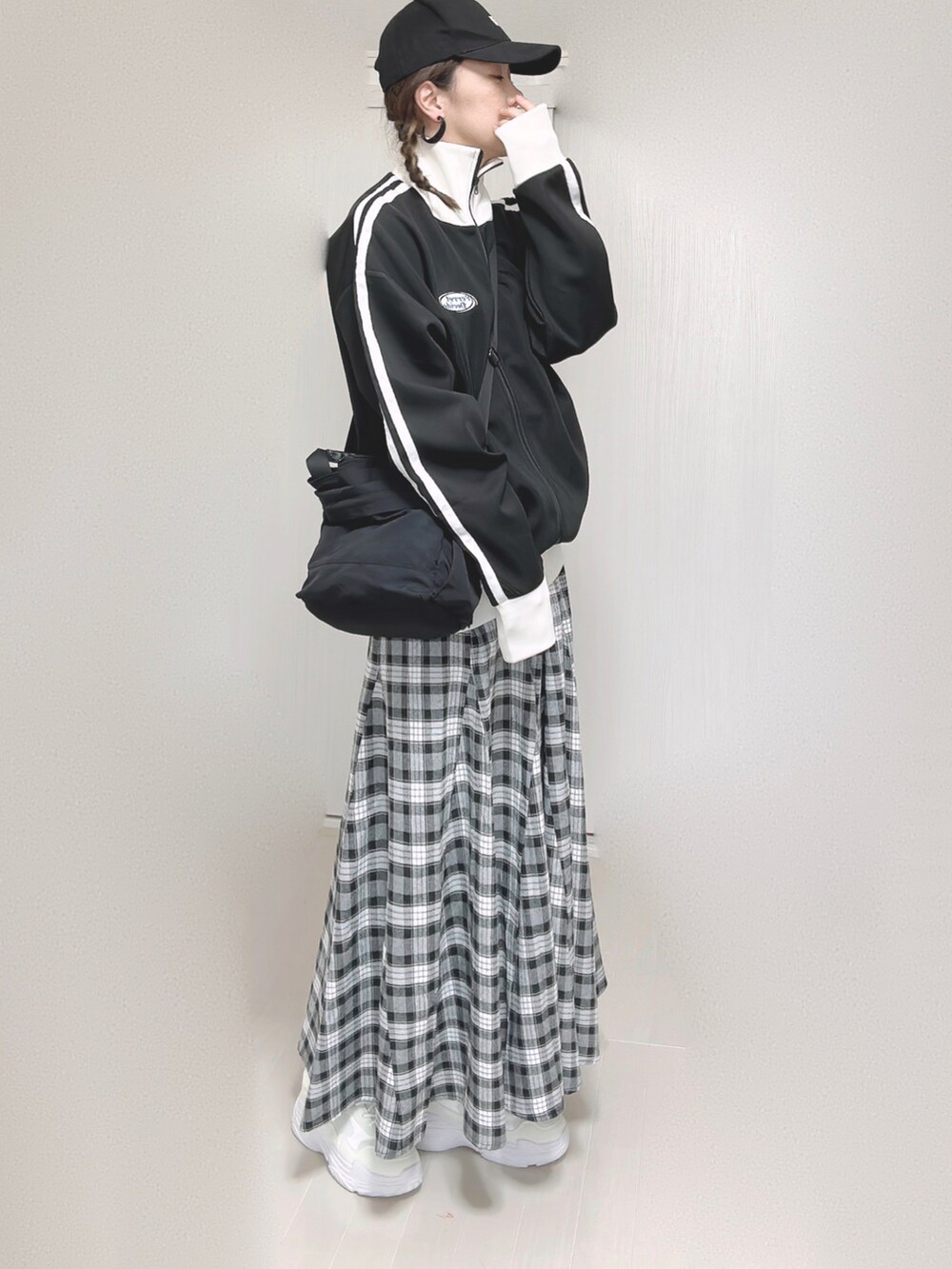 ブラック系のブルゾン、ブラック系のショルダーバッグ、ブラック系のスカートを着用したレディースの秋コーディネートの2枚目の写真