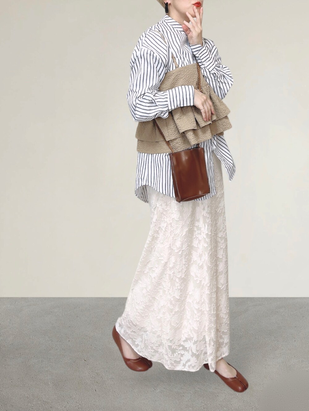 ベージュ系のキャミソール、ホワイト系のシャツ/ブラウス、ブラウン系のショルダーバッグを着用したレディースの秋コーディネートの5枚目の写真